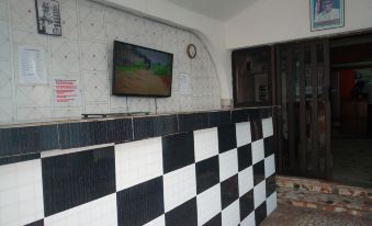 a black and white checkered tile wall with a television mounted above a reception desk at Crown Hotel