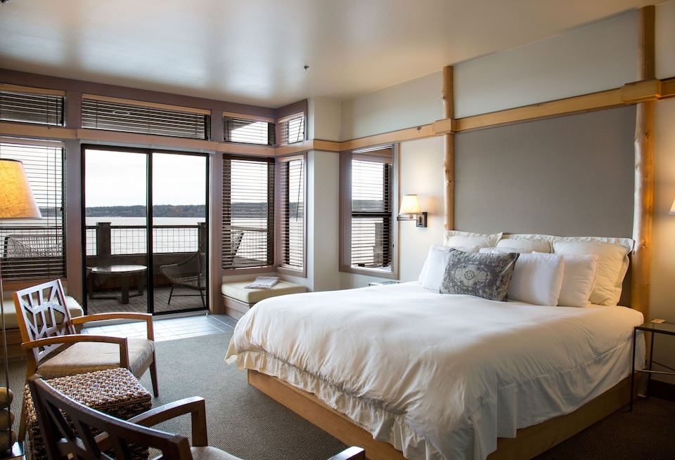 a large bedroom with a king - sized bed , a chair , and a view of the ocean at The Inn at Langley
