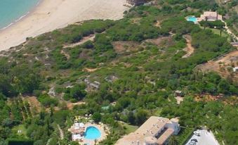 aerial view of a resort with multiple buildings , a pool , and a beach in the background at Hotel Casabela