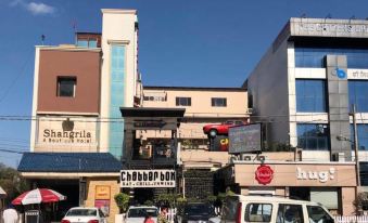 a busy city street with numerous cars , trucks , and motorcycles parked along the side of the road at Hotel Shangri la