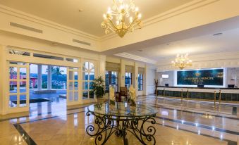 a large , elegant hotel lobby with marble floors , a marble chandelier hanging from the ceiling , and multiple tables and chairs arranged for meetings or events at Bahia Principe Grand Cayacoa