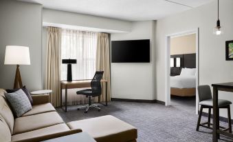 a modern hotel room with a comfortable couch , a tv on the wall , and a bed in the corner at Residence Inn Philadelphia Langhorne