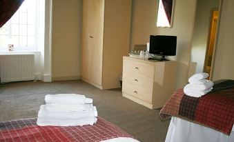 a hotel room with two beds , one on the left and one on the right at Anglers Arms
