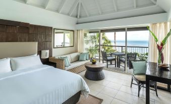 a spacious bedroom with a large bed , a couch , and a view of the ocean at Shangri-La Yanuca Island, Fiji