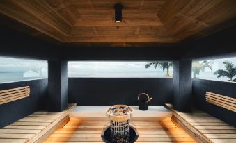 a wooden table with a teapot on it , surrounded by black walls and a black curtain at Sankara Hotel & Spa Yakushima