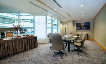 a conference room with chairs arranged in a semicircle around a table , and a large window in the background at Pan Pacific Vancouver