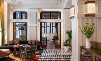 a modern , white - walled room with black and white checkered flooring , featuring an open door leading to another room at Canopy by Hilton Philadelphia Center City