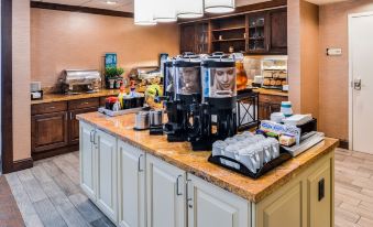 a kitchen counter with multiple coffee makers and various items on display , including cups , bottles , and other kitchen items at Homewood Suites by Hilton Dover