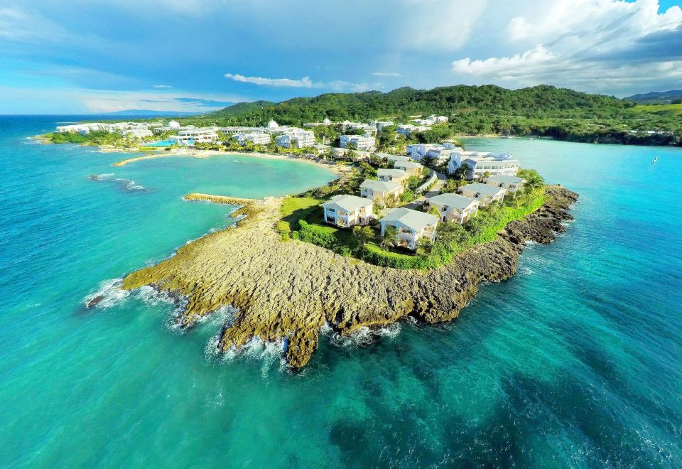 a small island with houses is surrounded by the ocean and is located in the middle of the island at Grand Palladium Lady Hamilton Resort & Spa - All Inclusive