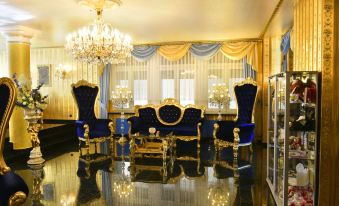 a luxurious living room with blue and gold furniture , including a couch , chairs , and a coffee table at Hotel Alexandra