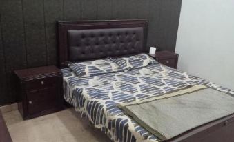 a bed with a dark brown headboard and blue and white patterned bedding is shown in a bedroom at Parkway Apartments