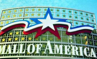 "a large building with a red , white , and blue sign that reads "" hotel of america .""." at Courtyard Minneapolis-St. Paul Airport