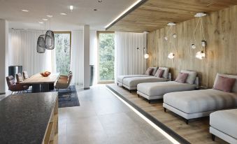 a modern living room with white couches and chairs arranged in a row , creating a comfortable and inviting atmosphere at Steigenberger Hotel and Spa, Krems