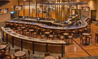 a large , well - lit restaurant with multiple dining tables and chairs , as well as a bar area at Lodge at Feather Falls Casino