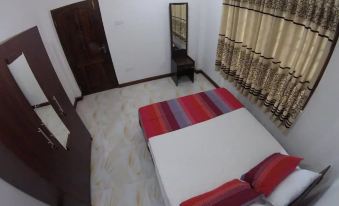 a modern bedroom with a white bed , red and gray striped comforter , and a window with curtains at Heaven Rest