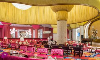 a large , modern restaurant with multiple dining tables and chairs , as well as an interior design featuring a yellow ceiling at Okada Manila