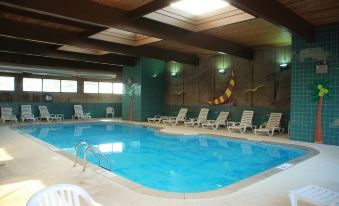 a large swimming pool with a row of lounge chairs and a wall decoration in the background at Riverview Inn