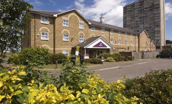 a large building with a purple sign in front of it , surrounded by greenery and bushes at Margate