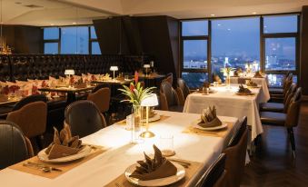 a well - lit dining room with tables set for a meal , each table having its own unique decoration and utensils at SureStay Hotel by Best Western Vientiane