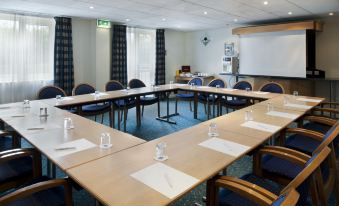 a conference room set up for a meeting , with several chairs arranged in a semicircle around a table at Holiday Inn Express Newcastle Gateshead