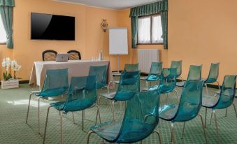 a conference room with chairs arranged in rows and a television mounted on the wall at Hotel Cristallo