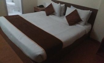a large bed with a white and brown blanket is shown in a hotel room at The Esquire