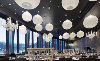 a modern restaurant with white balloons hanging from the ceiling , creating a festive atmosphere for guests at Scandic Ishavshotel