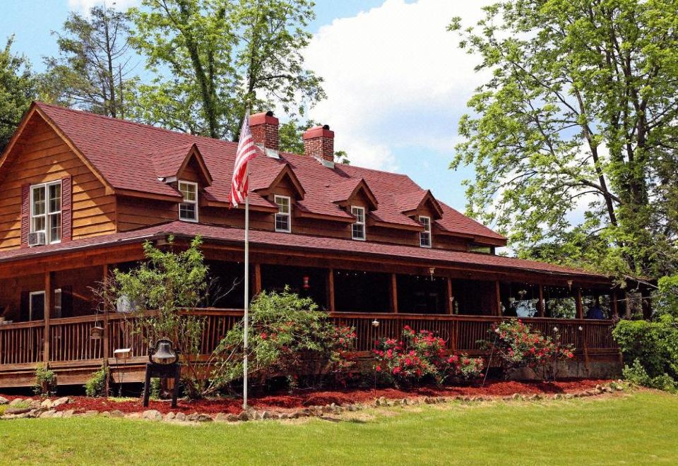 a large wooden house with a red roof and american flag on the front porch at Grandview Lodge
