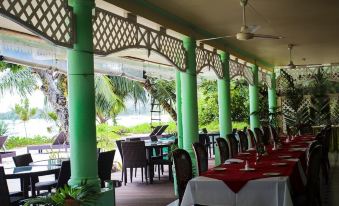 an outdoor dining area at a restaurant , with tables and chairs arranged for guests to enjoy a meal at Palm Beach Hotel
