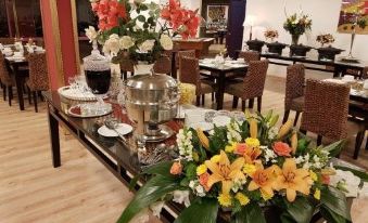 In the dining room of an upscale restaurant, there is a table adorned with flowers and various other items at Desert Sounds - Boutique Hotel