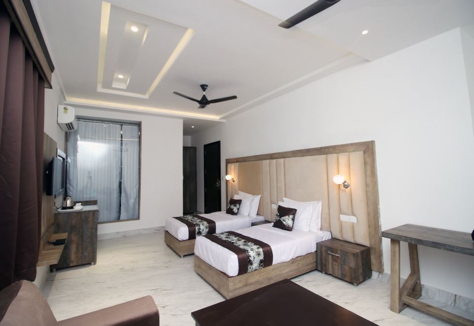 a modern bedroom with two beds , white walls , and wooden accents , including a ceiling fan at Hotel 8th Planet