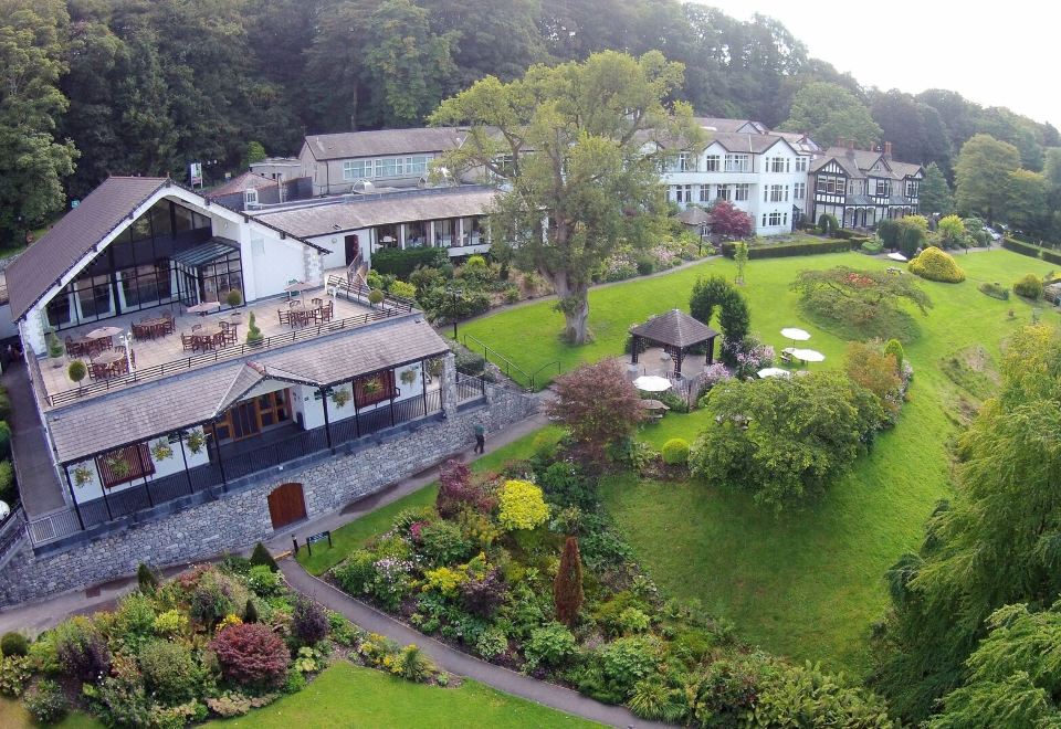 aerial view of a large house surrounded by green grass and trees , with a pool visible in the foreground at Castle Green Hotel in Kendal, BW Premier Collection