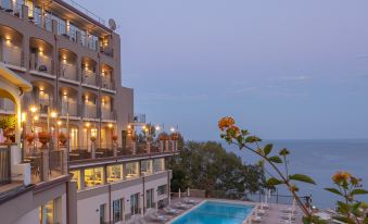 a large building with a swimming pool and several balconies is lit up at night at Hotel Antares