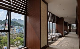 a modern , minimalist room with wooden walls and large windows offering a view of the city and mountains at Muong Thanh Luxury Son La