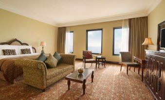 a large living room with a couch , chairs , and a coffee table in front of a window at Djibouti Palace Kempinski