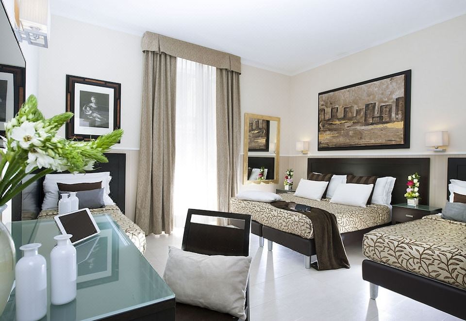 a luxurious hotel room with two beds , a large window , and a dining table in the living area at Yes Hotel