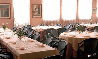 a well - decorated dining room with multiple tables and chairs arranged for a group of people at Hotel Europa