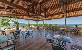 a wooden deck overlooking a body of water , with several chairs and tables placed throughout the area at Belambra Clubs Montpezat - le Verdon