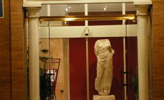 "a hotel entrance with a large sculpture of a woman in the window , and the name "" novahoma hotel "" written on a white sign" at Nova Roma