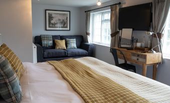 a cozy bedroom with a bed , couch , and tv . also a dining table in the room at The Exeter Inn