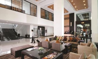 a spacious lobby with a high ceiling , multiple couches , chairs , and tables , as well as a staircase leading to an upper level at Kantary Hotel Kabinburi