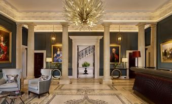 a luxurious hotel lobby with marble floors , ornate decorations , and a large chandelier hanging from the ceiling at The Langley, a Luxury Collection Hotel, Buckinghamshire