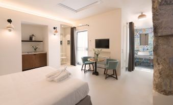 a modern bedroom with a bed , desk , and chair is shown next to a bathroom at Masseria Amastuola Wine Resort