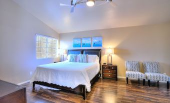 a spacious bedroom with hardwood floors , a large bed , and a ceiling fan hanging from the ceiling at Arrowhead