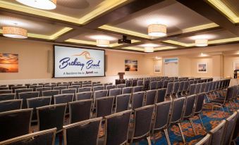 "a large conference room with rows of chairs arranged in front of a projector screen displaying "" bethany grove ""." at Bethany Beach Ocean Suites Residence Inn