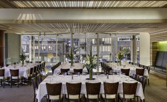 a large dining room with tables and chairs set up for a formal event , possibly a wedding reception at Novotel Queenstown Lakeside