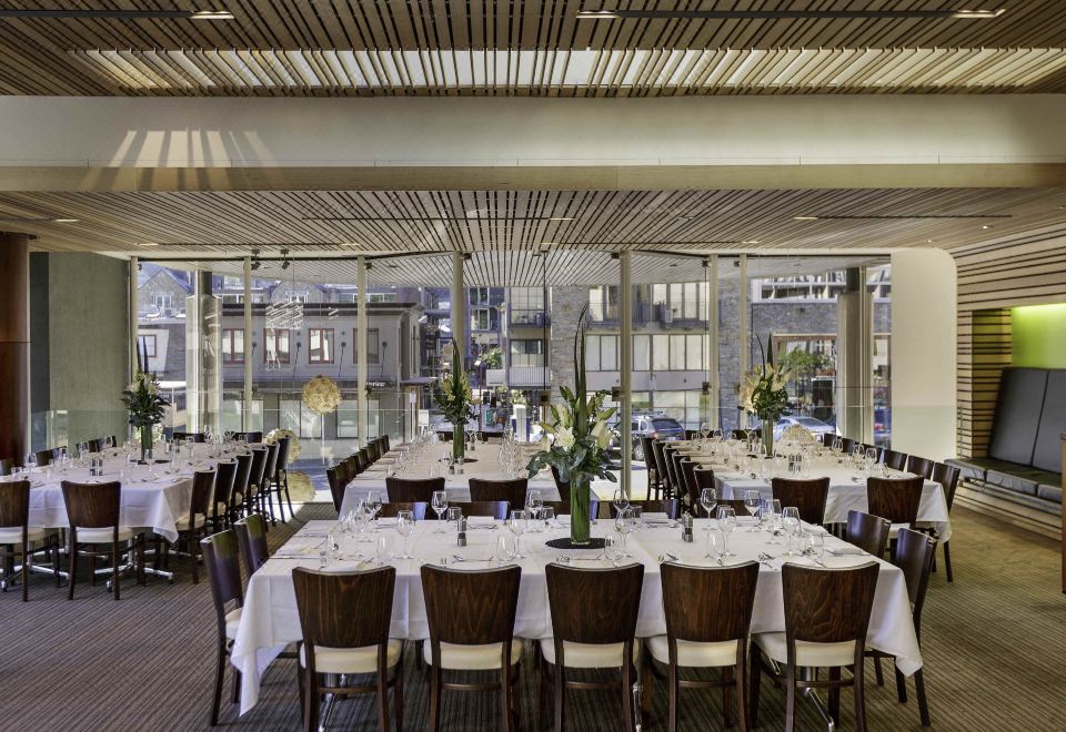 a large dining room with tables and chairs set up for a formal event , possibly a wedding reception at Novotel Queenstown Lakeside