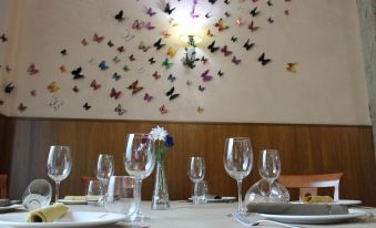 a dining room with a table set for a meal , adorned with butterflies on the wall at Hotel El Castillo