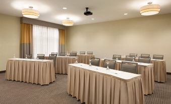 a conference room with multiple rows of chairs arranged in a semicircle , and a podium at the front of the room at Homewood Suites by Hilton Frederick
