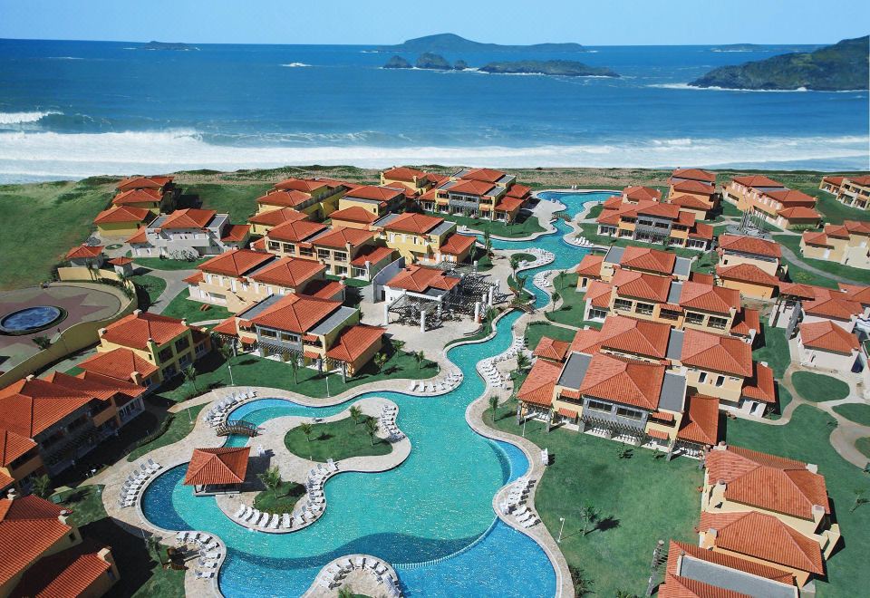aerial view of a resort with multiple buildings , swimming pools , and lush greenery surrounding the area at Búzios Beach Resort Luxo II